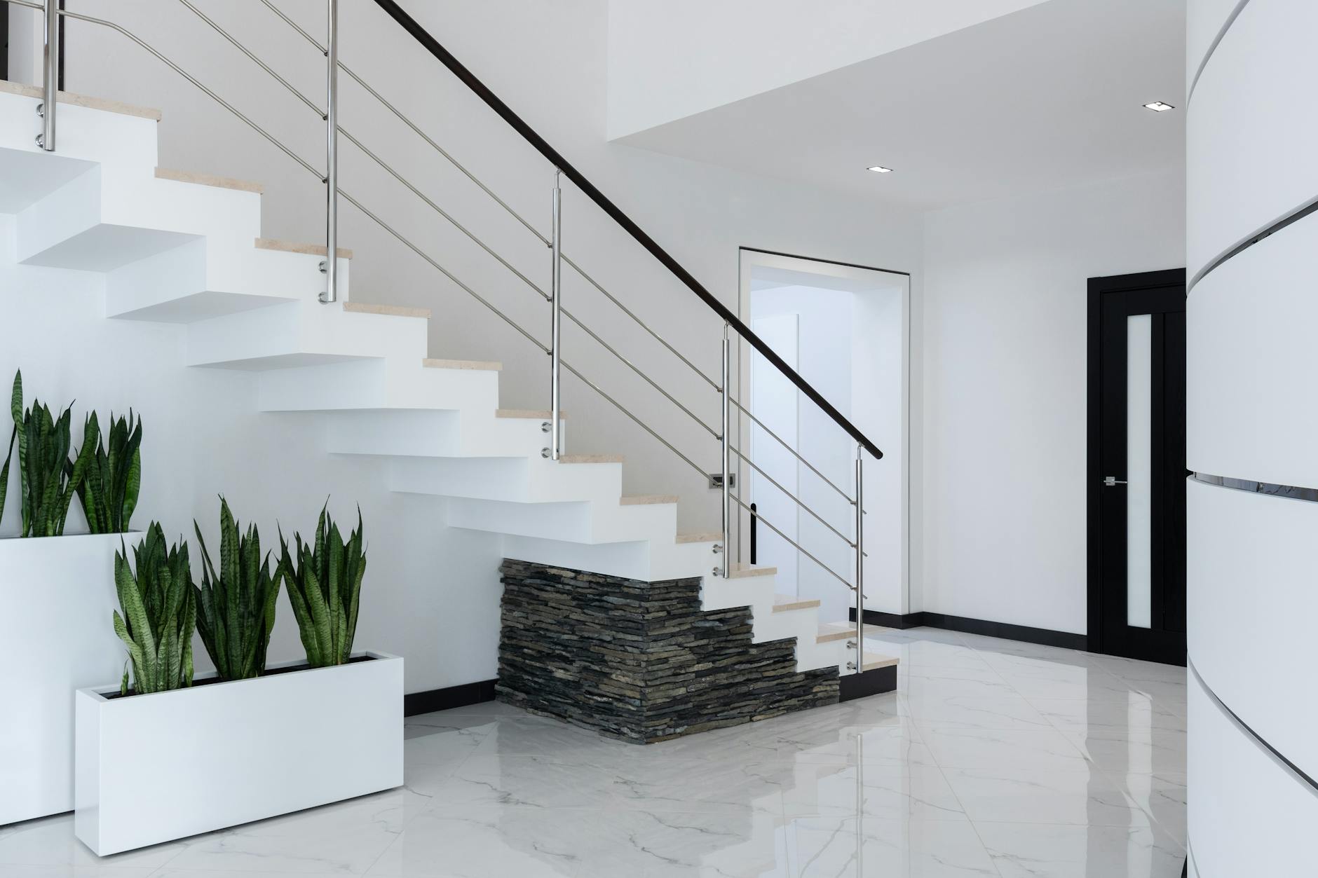 Elegant contemporary interior with a minimalist staircase and green plants.